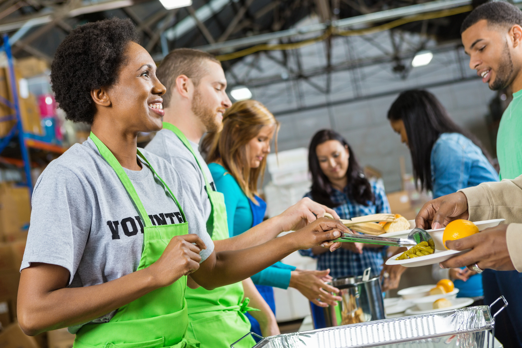 Volunteers serving healthy hot meal at soup kitchen